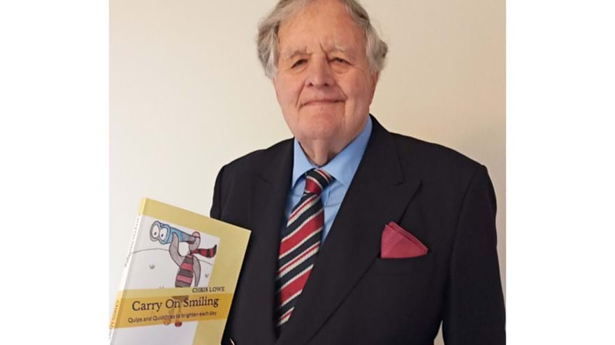 Blind veteran Chris holding up his book 'Carry on Smiling'