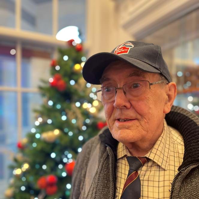 Blind veteran Alan standing beside a Christmas tree at our Llandudno Centre for Christmas
