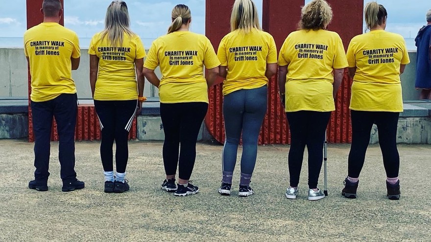 Blind veteran Griff's family, showing the back of their memorial t-shirts displaying text that says: Charity walk in memory of Griff Jones