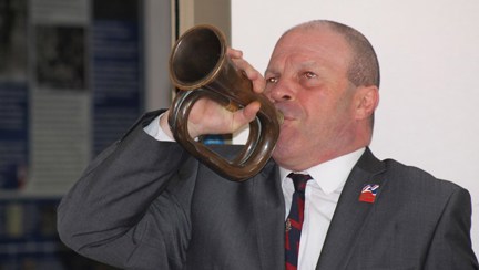 Blind veteran Billy blowing into a trumpet