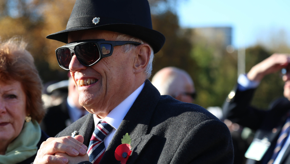 Blind veteran John, wearing dark glasses, at a Remembrance parade