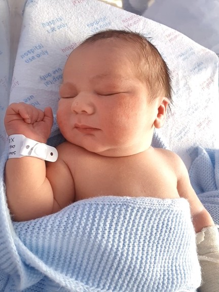 Sonny is covered with a blue blanket and has his eyes closed