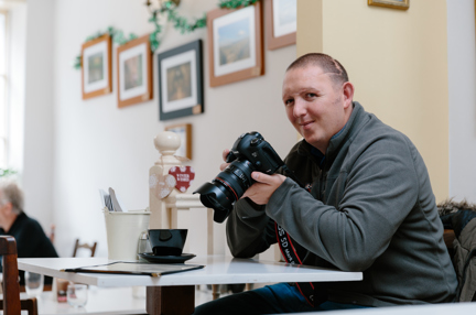 A photo of Chris a blind veteran using a camera