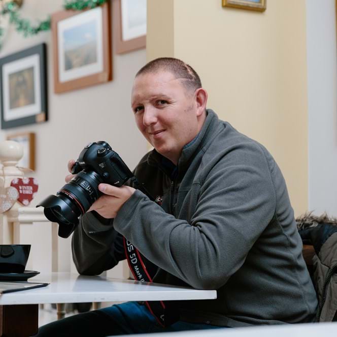 A photo of Chris a blind veteran using a camera