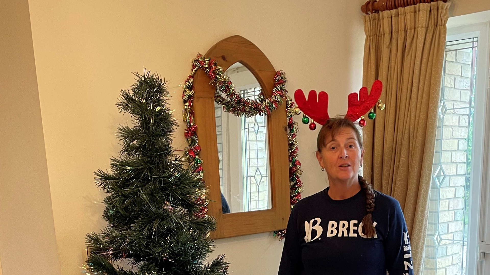 Jan standing next to her decorated Christmas tree