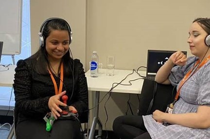 Two students with headphones on test the game