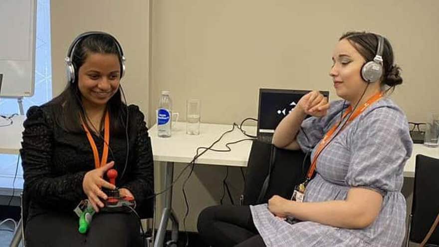 Two students with headphones on test the game