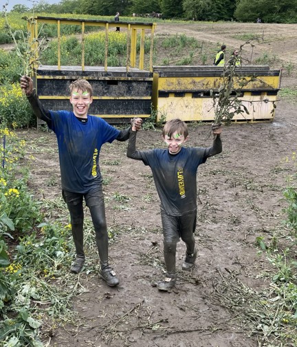 Sammy and Oakley holding hands and covered in mud from head to toe