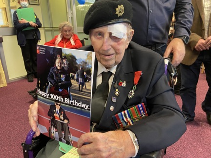 Blind veteran Ken smiling and holding up the card of himself and Margaret
