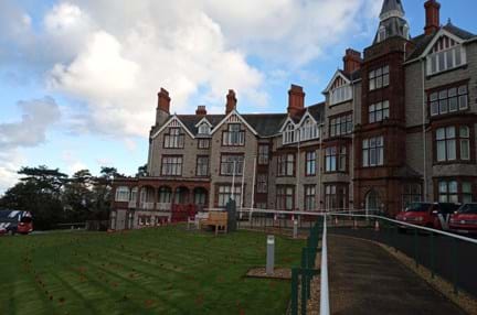 The front of the Llandudno Centre with knitted poppies placed around the front lawn