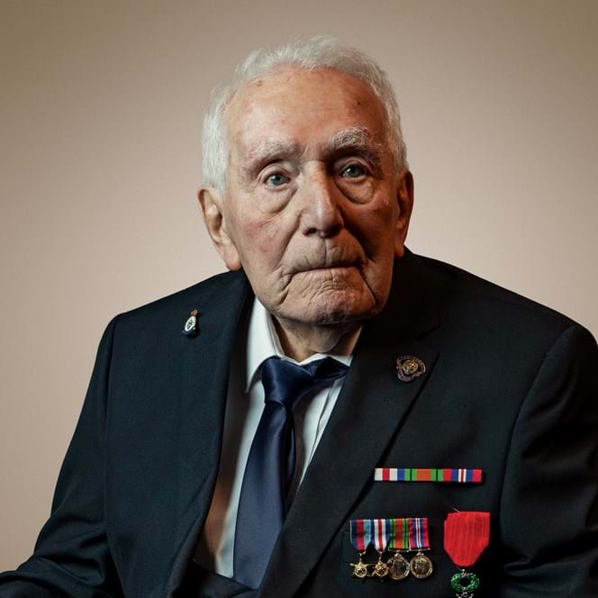 Blind veteran Bill, wearing a suit and his medals