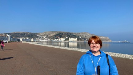 Blind veteran Sheila holding her cane while enjoying a walk at the coast