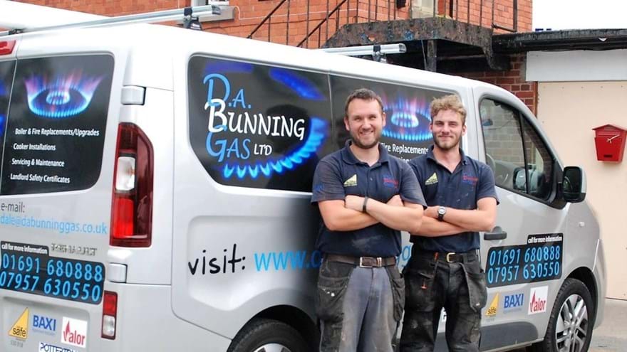 Charity supporter Dale and his colleague, standing in front of their work van, smiling.