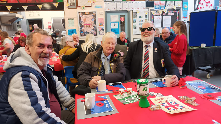Blind veterans Alex, Gary & Hugh At Ledley Hall Remembrance Service sitting with cups of tea around a table