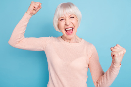 An elderly woman celebrating and cheering with a joyful expression