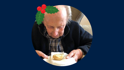 Blind veteran Ken wearing a Christmas hat, detailed with an illustration of holly.