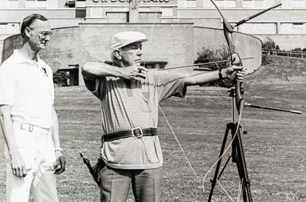 A black and white photograph of blind veteran Jerry Lynch perfecting his aim in archery in front of our Brighton centre