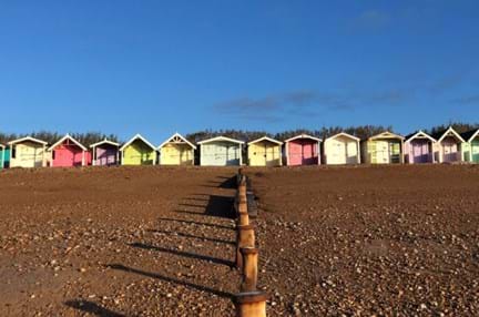 A row of colourful beach huts on the coast at the rustington centre