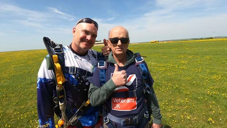 Mark and his instructor stood together in the field where they landed with thumbs up