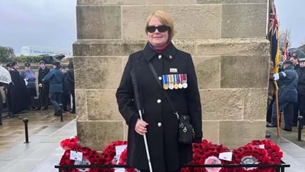 Blind veteran Sheila with a wreath at the Swansea war memorial