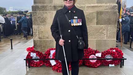 Blind veteran Sheila with a wreath at the Swansea war memorial