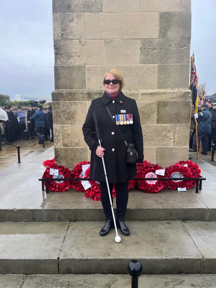 Blind veteran Sheila with a wreath at the Swansea war memorial