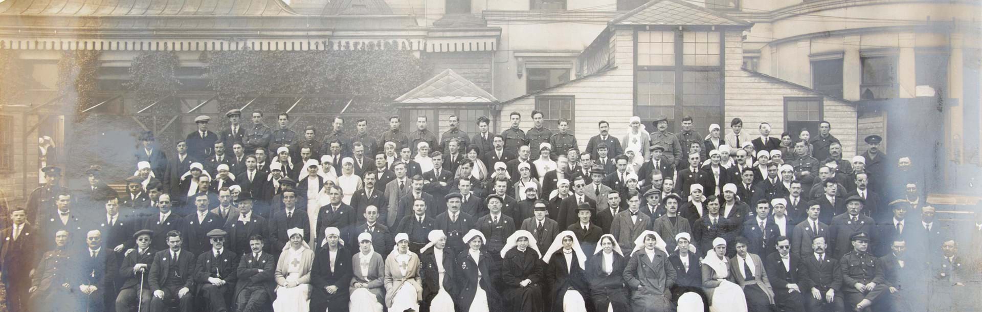 An archive group photograph of blind veterans, nurses and staff outside our headquarters at Regents Park in 1918