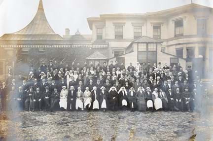 An archive group photograph of blind veterans, nurses and staff outside our headquarters at Regents Park in 1918