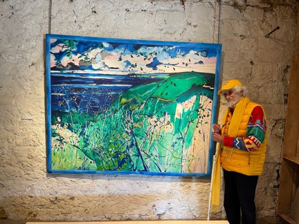 Blind veteran Philip stands with a white cane on the right hand side of his artwork
