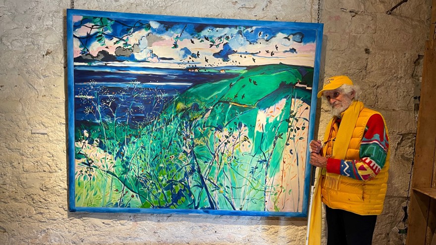 Blind veteran Philip stands with a white cane on the right hand side of his artwork