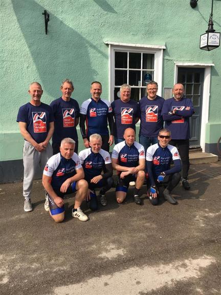 A group picture of ten men who make up the cyclists for the 400 mile bike ride and their support crew all wearing Blind Veterans UK tops