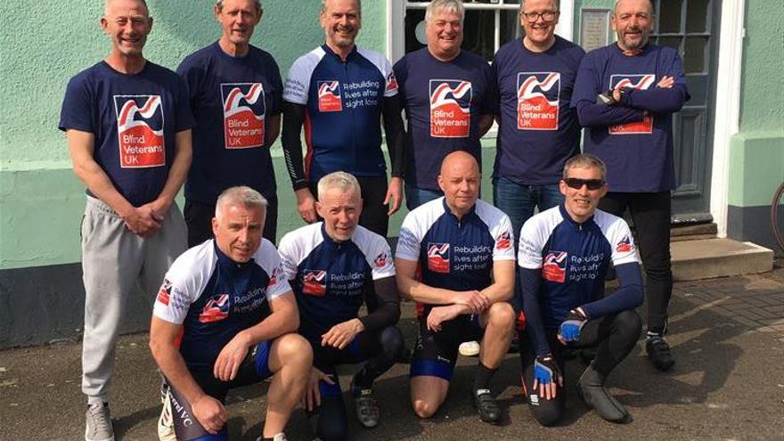 A group picture of ten men who make up the cyclists for the 400 mile bike ride and their support crew all wearing Blind Veterans UK tops