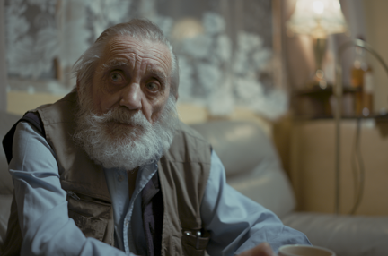 Photo of blind veteran Ken sitting on sofa at home