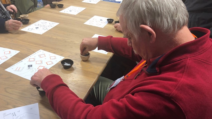 Blind veterans sat around at a table, reaching into small containers of salt