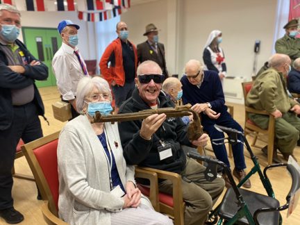 Photo of blind veteran Barry, right, and wife Joan, left, holding a gun during demonstration