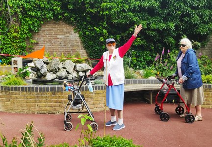 Blind veteran Nancy raises her arm in celebration of completing 100th lap