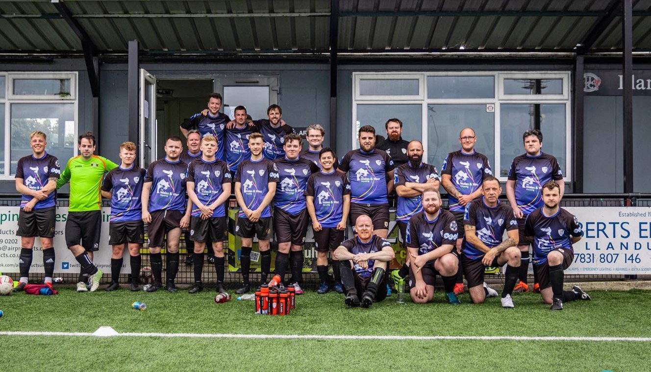 Group photograph of the team wearing their football kit of blue t-shirts and black shorts