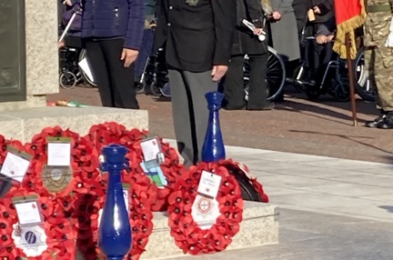 Blind veteran Victor, wearing his medals and uniform, salutes after laying a poppy wreath