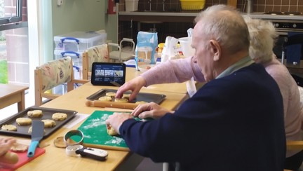 A photo of blind veteran Ian and his wife Mabel rolling out dough for Welsh cakes with the help of Alexa