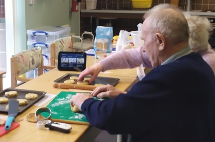 A photo of blind veteran Ian and his wife Mabel rolling out dough for Welsh cakes with the help of Alexa