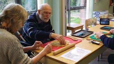 A photo of blind veteran Jack and his wife Molly rolling out dough to make Welsh cakes with the help of Alexa