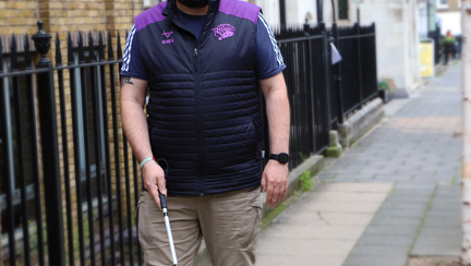 A photo of blind veteran Simon with white cane