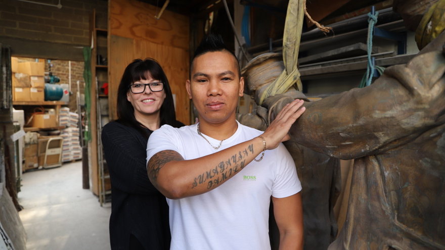 A photo of artist and sculptress Johanna Domke-Guyot with blind veteran Ken Facal and her Victory Over Blindness statue