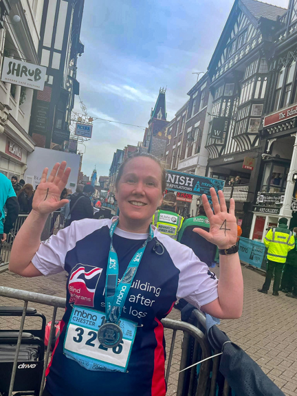 Alison with a huge smile in her Blind Veterans UK vest after finishing the Chester 10k