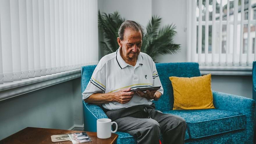 Fred, a blind veteran, using a tablet while at our centre of wellbeing in Llandudno 