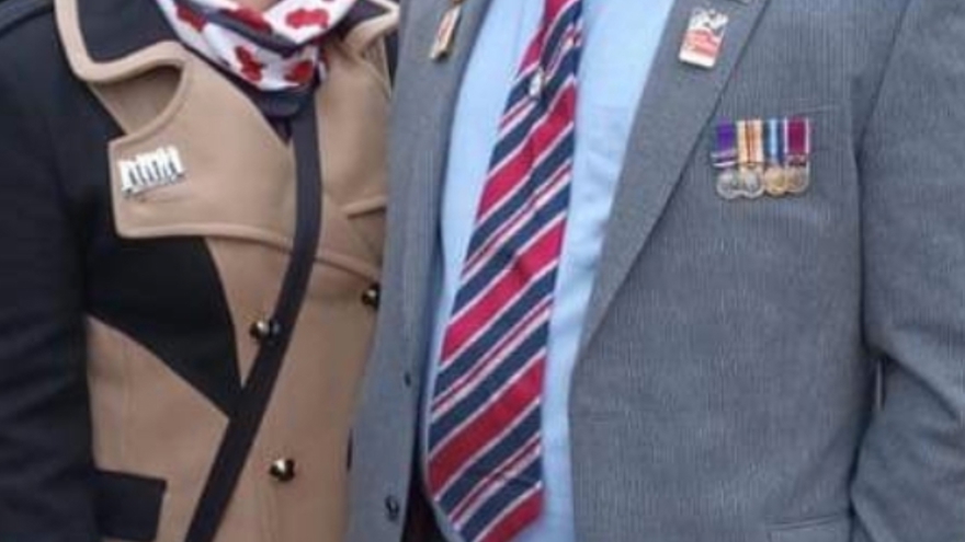 A photo of blind veteran Andrew, right, wearing his military badges