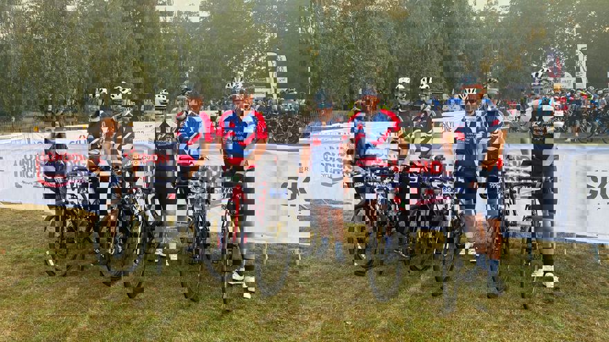 A group of six Thea employees holding up their bikes and wearing their Blind Veterans UK cycling tops