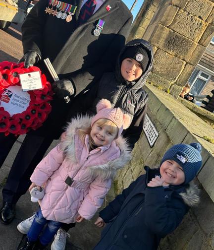 Colin and his three of his grandchildren with a wreath of poppies