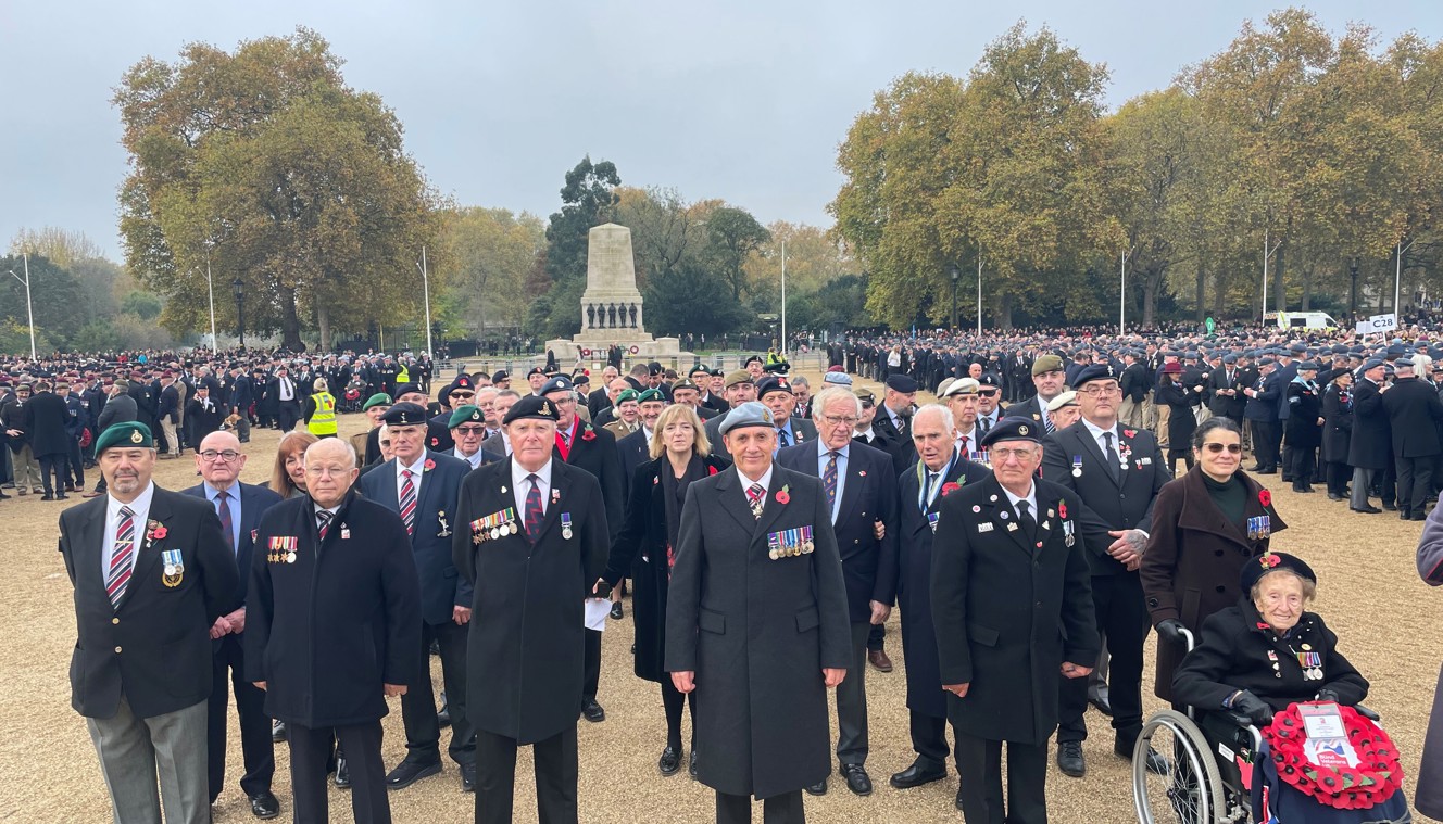 Blind veterans and guides gathered together, wearing their badges and poppys for Remembrance