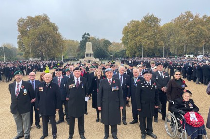 Blind veterans and guides gathered together, wearing their badges and poppys for Remembrance